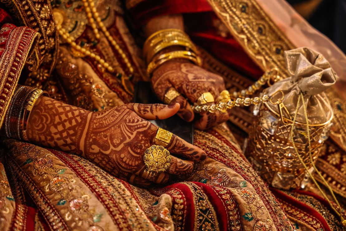 A bride's henna-painted hands with gold jewelry are pictured during a wedding in Jammu and Kashmir, India on October 3, 2023.